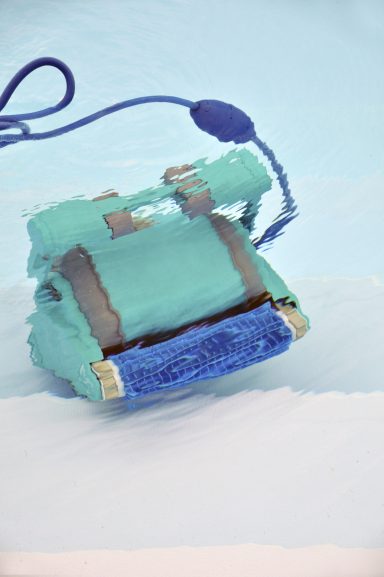 Türkisfarbene Schwimmhilfe mit blauer Schnur im Wasser.